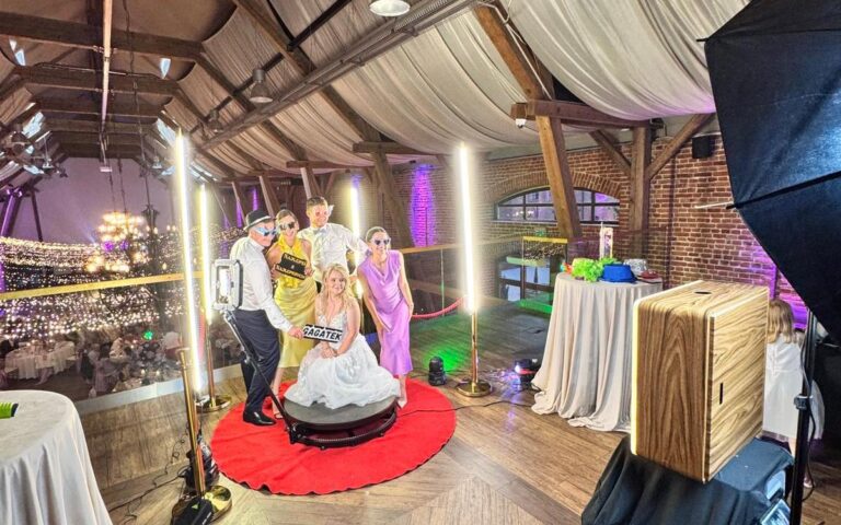 Goście na obrotowej platformie fotobudki 360 podczas wesela w stodole