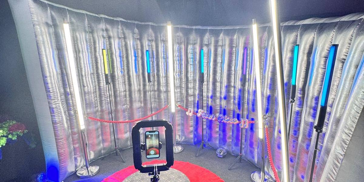 Stanowisko fotobudki 360 — obrotowa platforma, czerwony dywan i neonowe tuby LED