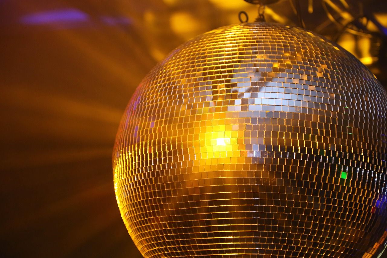 Złota kula disco w ultrafioletowym świetle — neonowa fotobudka fluo na imprezie klubowej